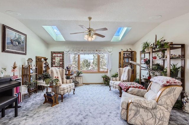 sitting room with carpet, baseboards, a ceiling fan, and lofted ceiling with skylight
