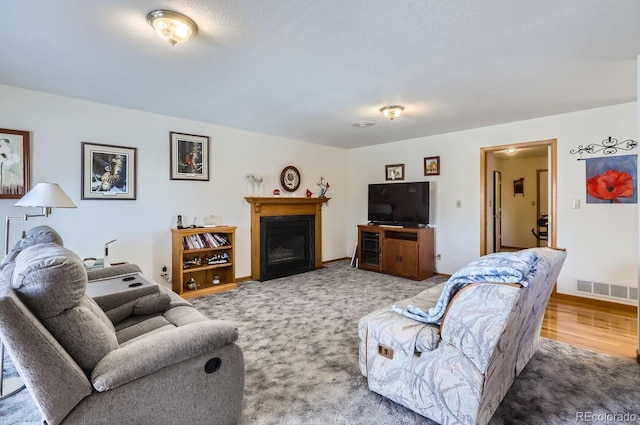 living area featuring visible vents, baseboards, and a fireplace with flush hearth