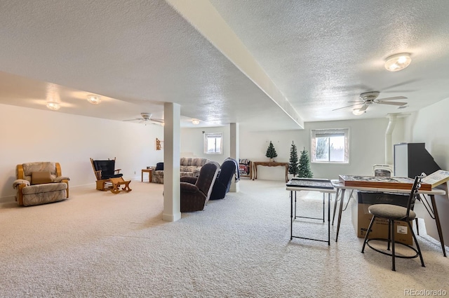living area featuring a textured ceiling, ceiling fan, a wealth of natural light, and carpet floors