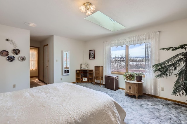 bedroom featuring a skylight, carpet, and baseboards
