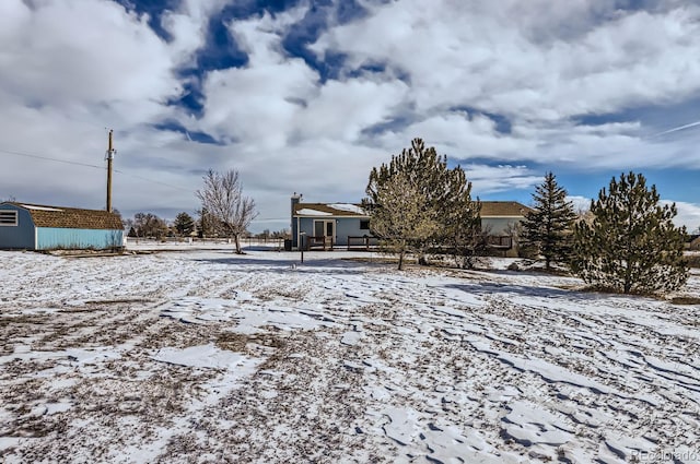 snowy yard with an outbuilding and a storage unit