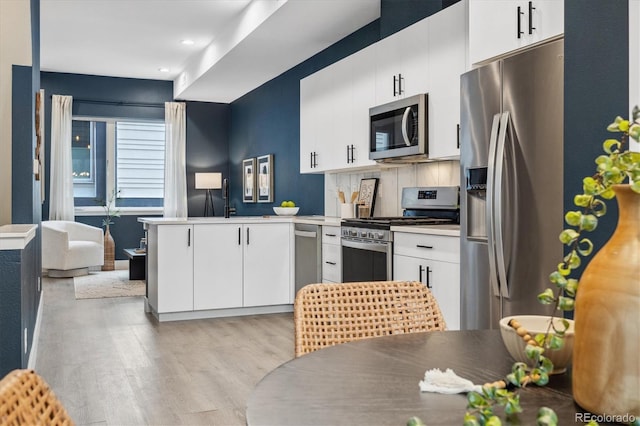 kitchen featuring light wood-type flooring, white cabinetry, appliances with stainless steel finishes, and a sink