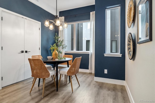 dining area featuring a notable chandelier, wood finished floors, and baseboards