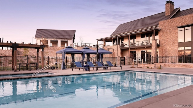 pool at dusk with a patio