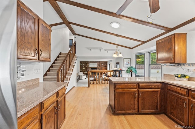 4677 S Wolff St, Denver, CO 80236 - kitchen with a peninsula, light wood-style floors, decorative light fixtures, stainless steel fridge, and light stone counters