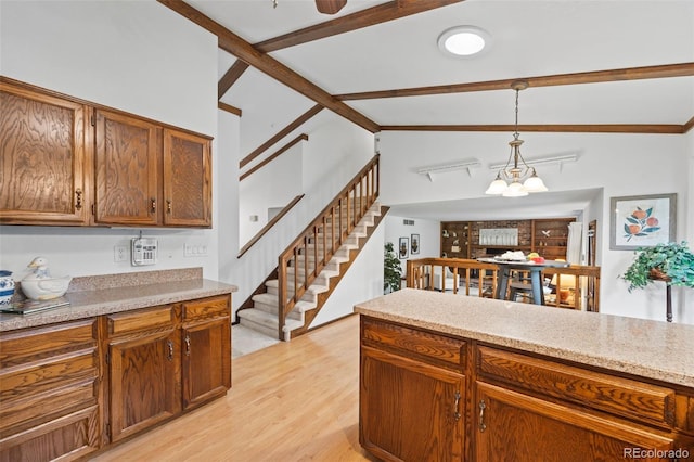 4677 S Wolff St, Denver, CO 80236 - kitchen with light wood finished floors, hanging light fixtures, a chandelier, and brown cabinets