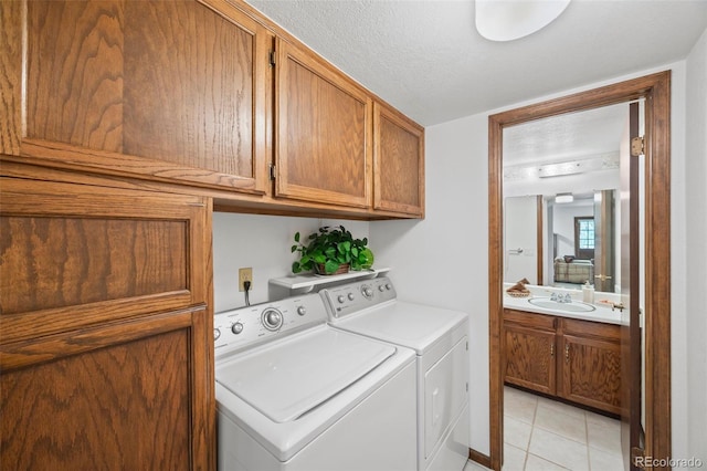 4677 S Wolff St, Denver, CO 80236 - laundry room with washer and clothes dryer, cabinet space, and light tile patterned floors