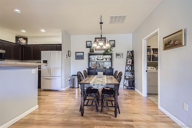 8445 S Holland Way Unit 205, Littleton, CO 80128 - dining room featuring washer / clothes dryer, a chandelier, light wood-style flooring, baseboards, and recessed lighting