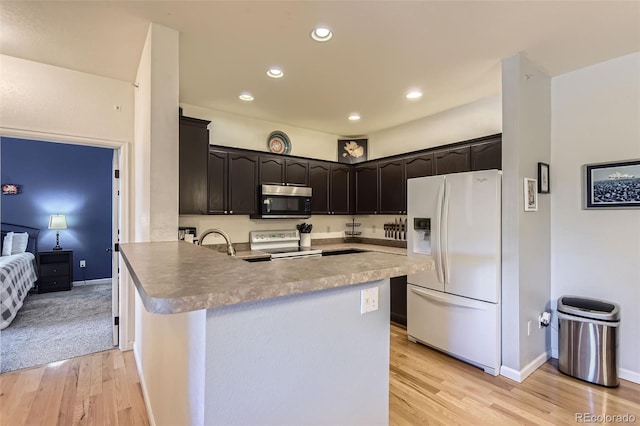 8445 S Holland Way Unit 205, Littleton, CO 80128 - kitchen featuring white appliances, a peninsula, light wood finished floors, recessed lighting, and baseboards