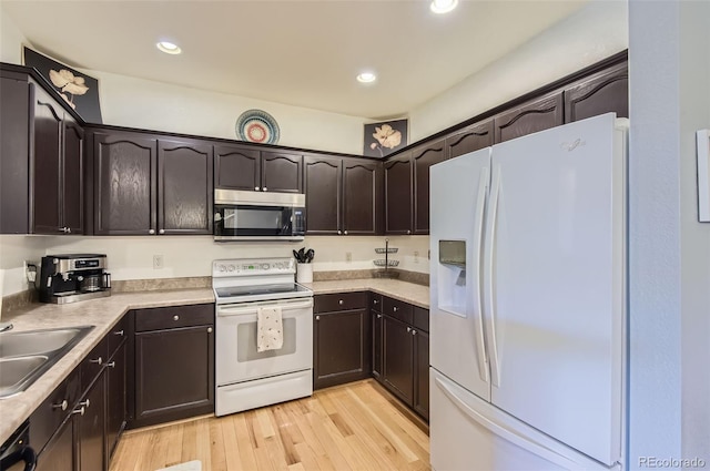 8445 S Holland Way Unit 205, Littleton, CO 80128 - kitchen featuring white appliances, dark brown cabinets, a sink, light countertops, and light wood-style flooring