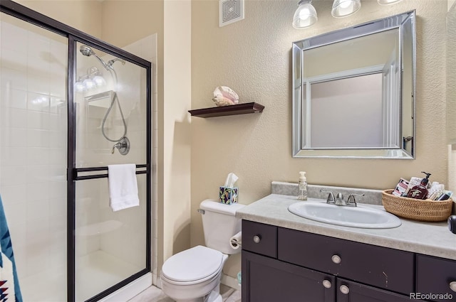 8445 S Holland Way Unit 205, Littleton, CO 80128 - bathroom featuring a shower stall, toilet, vanity, and a textured wall