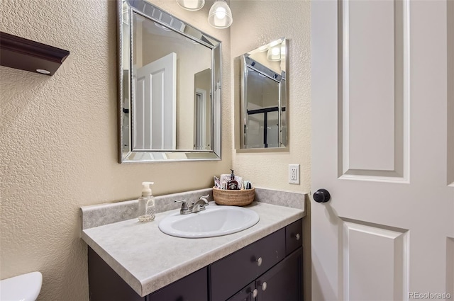 8445 S Holland Way Unit 205, Littleton, CO 80128 - bathroom featuring vanity, a textured wall, and toilet