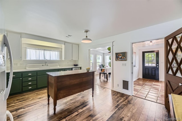 947 S Yates St, Denver, CO 80219 - kitchen with green cabinetry, light countertops, a sink, hardwood / wood-style floors, and pendant lighting