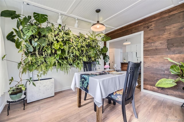 947 S Yates St, Denver, CO 80219 - dining room with light wood finished floors, wood walls, and baseboards