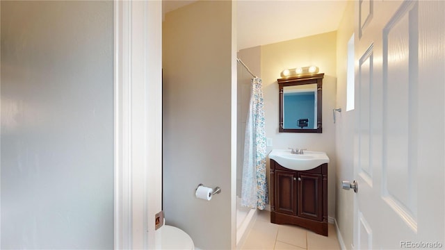 bathroom featuring tile patterned floors, toilet, vanity, and walk in shower