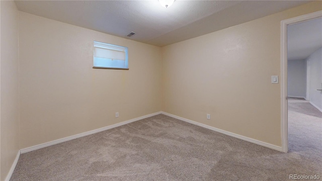 unfurnished room featuring light colored carpet and a textured ceiling