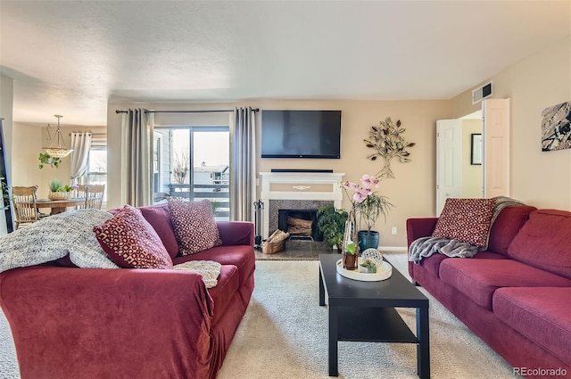 living area with baseboards, visible vents, carpet floors, and a premium fireplace