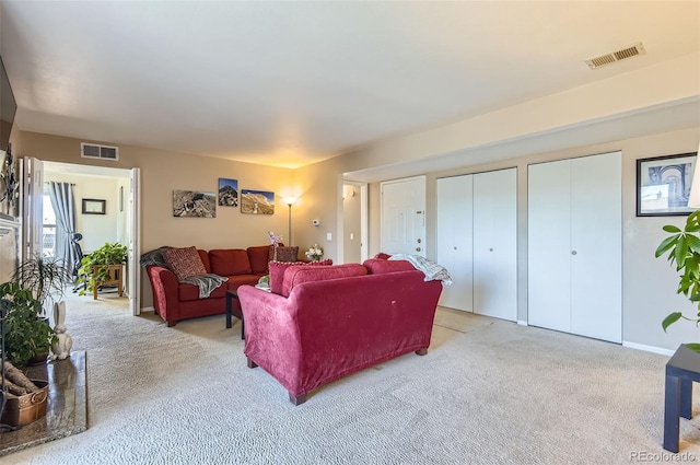 living area featuring light carpet and visible vents