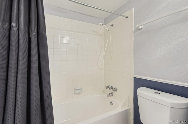 bathroom with toilet, a textured wall, and shower / bath combo