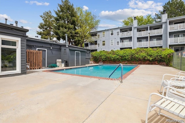 community pool with fence and a patio area