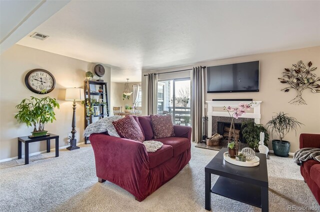 carpeted living area featuring visible vents, a fireplace, and baseboards