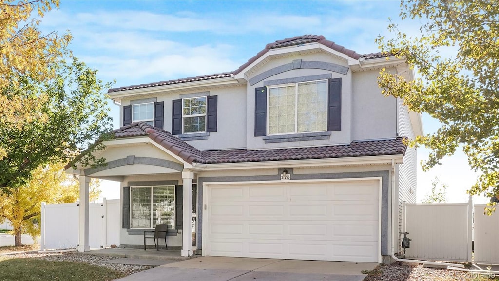 21296 E 55th Pl, Denver, CO 80249 - mediterranean / spanish-style home featuring a tiled roof, a garage, concrete driveway, and stucco siding
