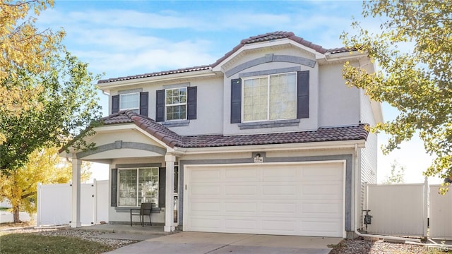 21296 E 55th Pl, Denver, CO 80249 - mediterranean / spanish-style home featuring a tiled roof, a garage, concrete driveway, and stucco siding