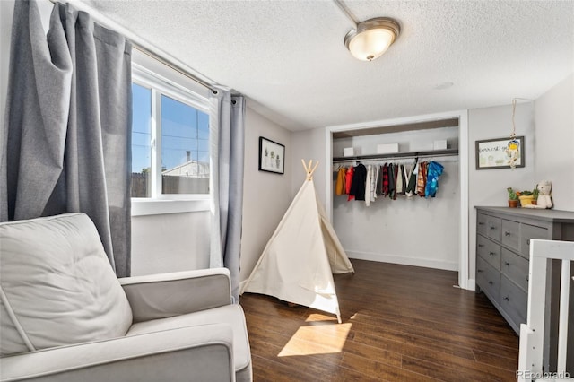 bedroom with baseboards, wood finished floors, a closet, and a textured ceiling