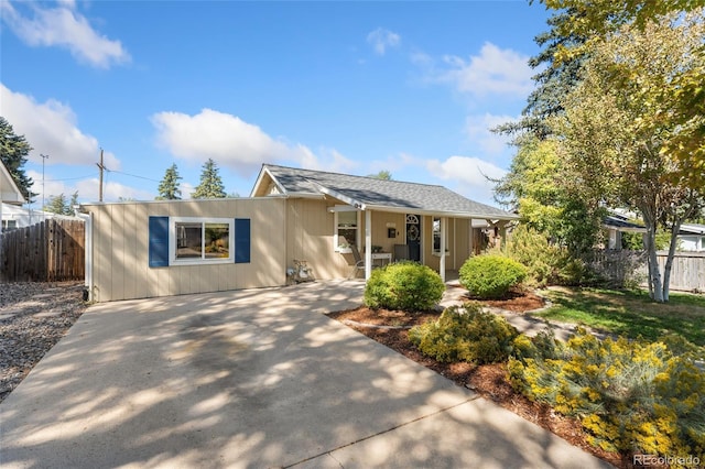 ranch-style home featuring covered porch and fence