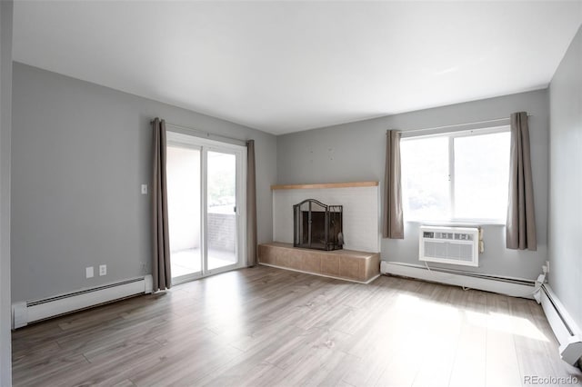 8330 Zuni St Unit 116, Denver, CO 80221 - unfurnished living room with baseboard heating, a fireplace, wood finished floors, and a wall mounted air conditioner
