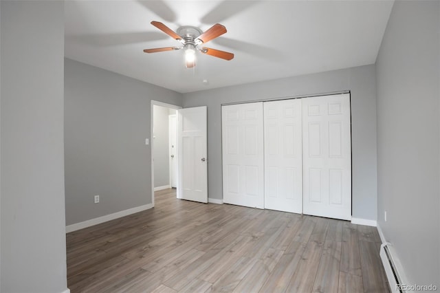 8330 Zuni St Unit 116, Denver, CO 80221 - unfurnished bedroom featuring a baseboard heating unit, wood finished floors, a closet, and a ceiling fan