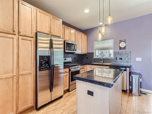 kitchen featuring light wood-type flooring, light brown cabinets, a sink, appliances with stainless steel finishes, and tile counters