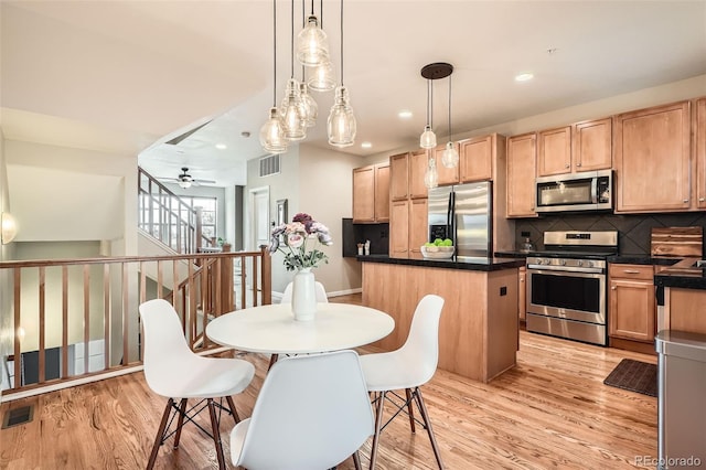 453 S Quay St, Lakewood, CO 80226 - kitchen featuring a kitchen island, appliances with stainless steel finishes, light wood-style flooring, and visible vents
