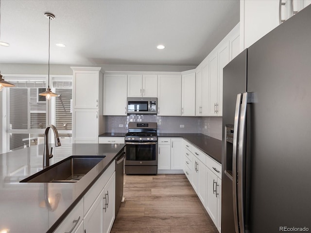 3654 Penang Dr, Castle Rock, CO 80109 - kitchen featuring appliances with stainless steel finishes, dark countertops, recessed lighting, backsplash, and pendant lighting