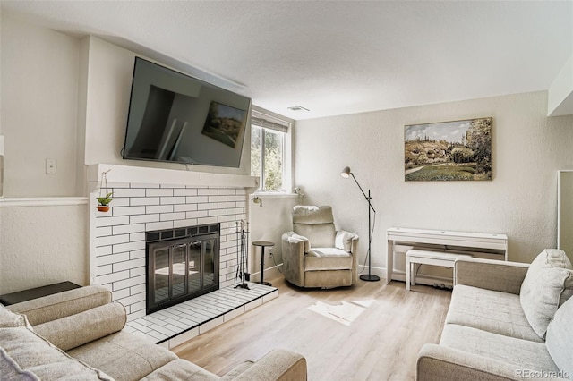 17630 E Loyola Dr Unit 1812L, Aurora, CO 80013 - living area featuring wood finished floors, a brick fireplace, and a textured wall