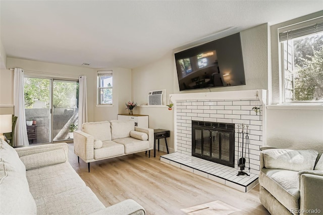 17630 E Loyola Dr Unit 1812L, Aurora, CO 80013 - living area with a fireplace, wood finished floors, and a wall mounted AC