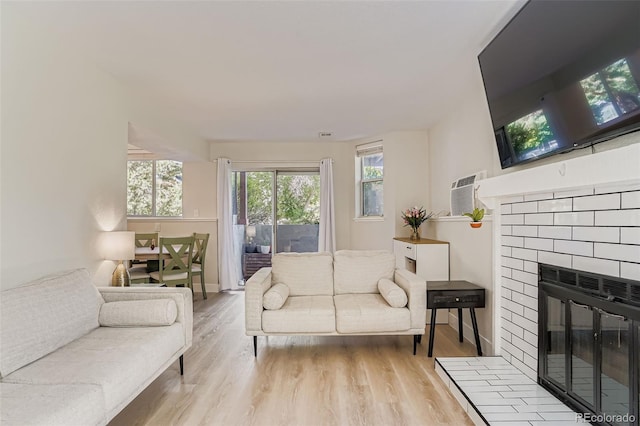 17630 E Loyola Dr Unit 1812L, Aurora, CO 80013 - living room with a brick fireplace, wood finished floors, and a wall unit AC