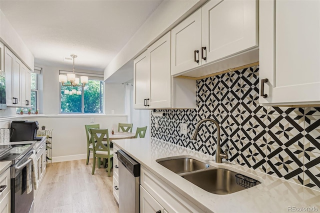 17630 E Loyola Dr Unit 1812L, Aurora, CO 80013 - kitchen with appliances with stainless steel finishes, white cabinets, decorative backsplash, and a chandelier