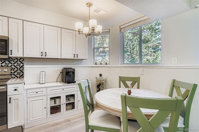 17630 E Loyola Dr Unit 1812L, Aurora, CO 80013 - dining area featuring a chandelier and light wood finished floors