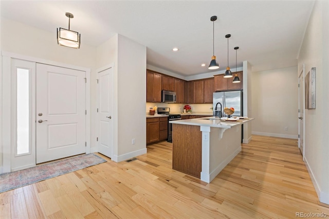 671 Robert St, Longmont, CO 80503 - kitchen with stainless steel appliances, light wood-style floors, a sink, light countertops, and baseboards