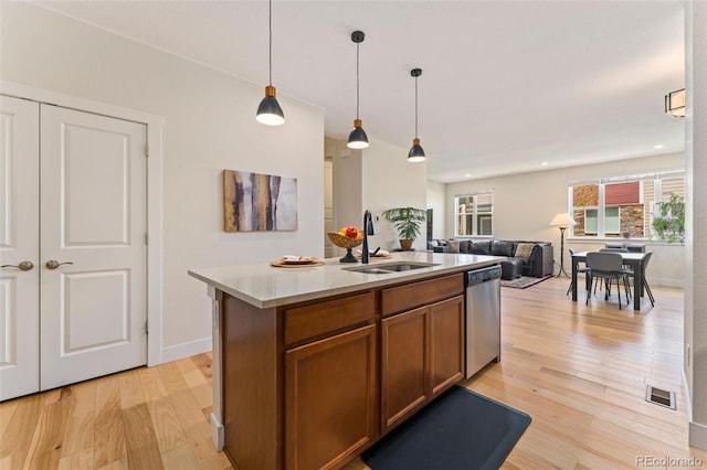 671 Robert St, Longmont, CO 80503 - kitchen with a sink, dishwasher, light wood finished floors, brown cabinets, and pendant lighting