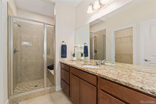 671 Robert St, Longmont, CO 80503 - bathroom with vanity, a stall shower, a spacious closet, and tile patterned flooring