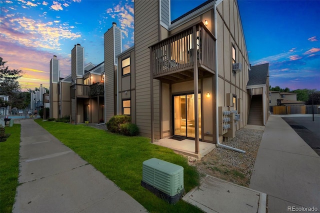 225 E 8th Ave Unit 10, Longmont, CO 80504 - back of property at dusk with a balcony, a yard, and a chimney
