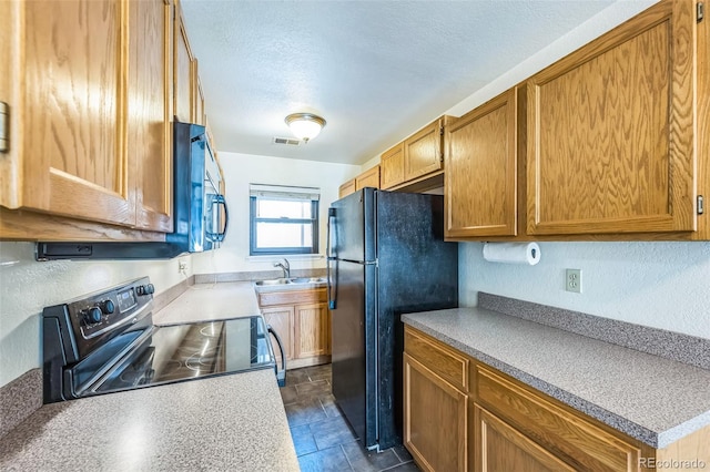 225 E 8th Ave Unit 10, Longmont, CO 80504 - kitchen featuring electric range, stainless steel microwave, freestanding refrigerator, a textured ceiling, and light countertops