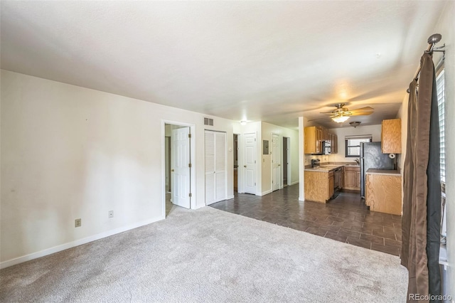 225 E 8th Ave Unit 10, Longmont, CO 80504 - unfurnished living room featuring dark carpet and ceiling fan