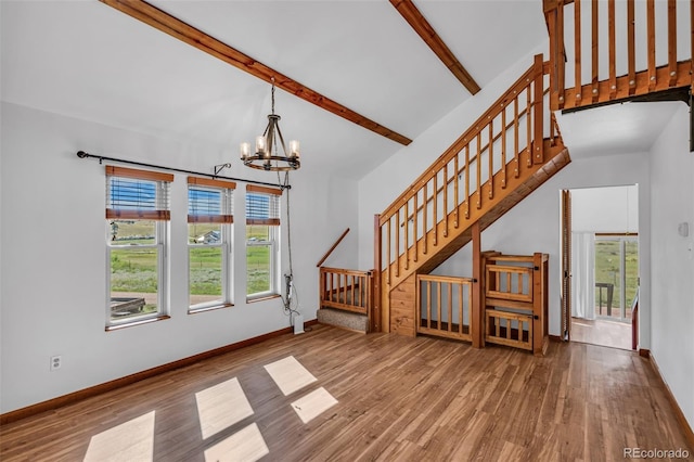 unfurnished living room featuring beam ceiling, a notable chandelier, hardwood / wood-style floors, and high vaulted ceiling