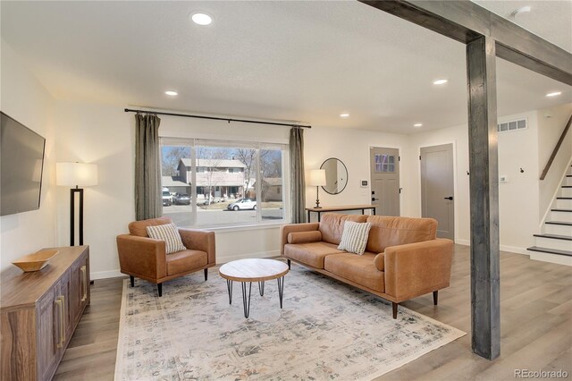 living room with visible vents, baseboards, stairway, light wood-type flooring, and recessed lighting