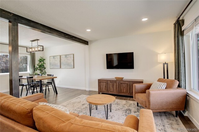 living room featuring beamed ceiling, recessed lighting, light wood-style flooring, and baseboards