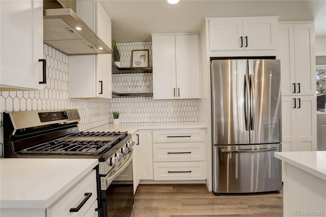 kitchen with open shelves, appliances with stainless steel finishes, wall chimney range hood, and light countertops