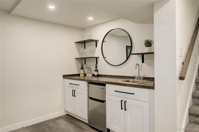 bar featuring baseboards, a textured wall, stairs, a sink, and recessed lighting